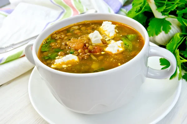 Sopa de lentejas con espinacas y feta en taza blanca a bordo — Foto de Stock