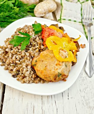 Cutlets of turkey with buckwheat and vegetables in plate on boar