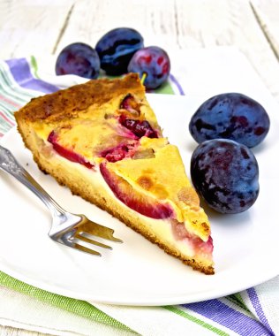 Pie plum with sour cream in plate on board