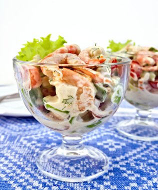 Karides ve cam masa örtüsü üzerine domates salatası