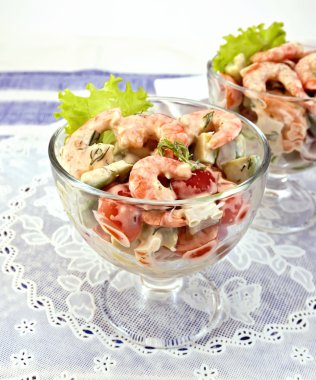 Karides ve cam beyaz peçete üzerine domates salatası