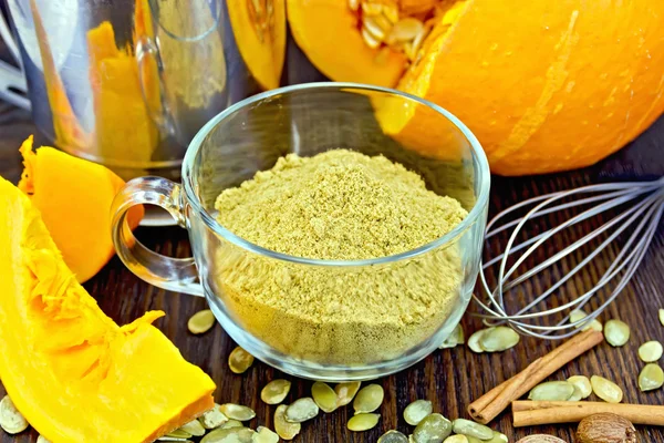 Flour pumpkin in glass cup with seeds and sieve on board — Stockfoto