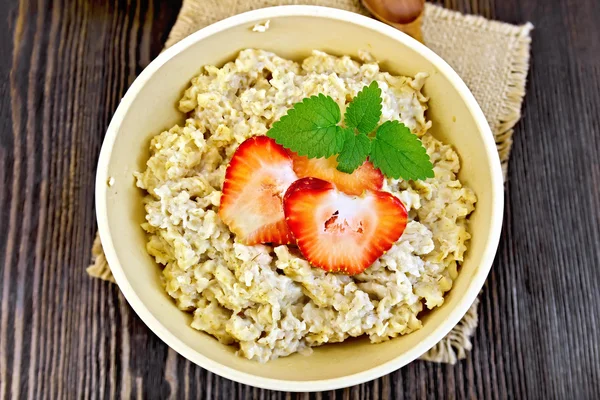 Oatmeal with strawberries on sacking top — ストック写真