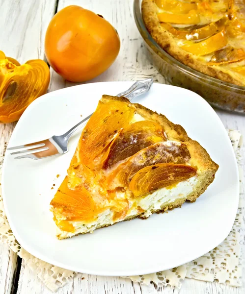 Pie with curd and persimmons in plate on napkin silicone — Stock Photo, Image