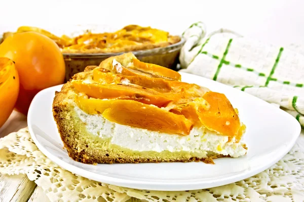 Pie with curd and persimmons in plate on napkin — 스톡 사진