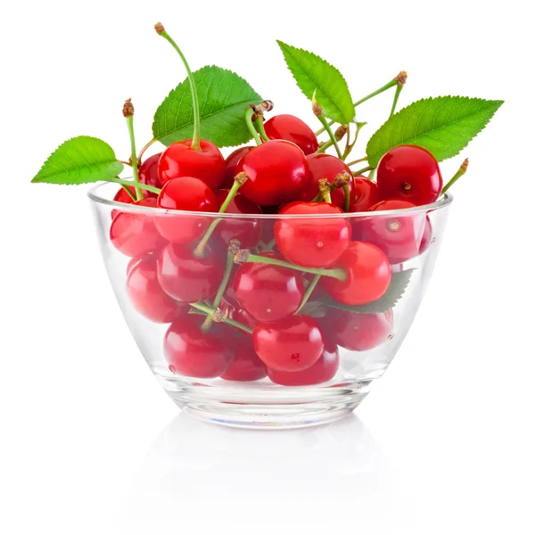 Cerises fraîches mûres avec des feuilles dans un bol en verre isolé sur blanc — Photo