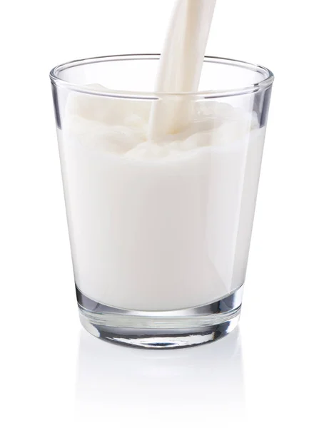 将牛奶倒入白色背景上隔离的玻璃中 — 图库照片