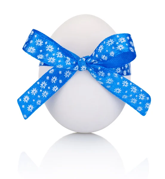 Пасхальное яйцо с праздничным голубым луком на белом фоне — стоковое фото