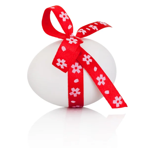 Пасхальное яйцо с праздничным красным луком на белом фоне — стоковое фото