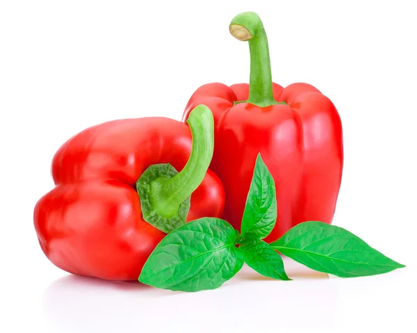 Twee zoete rode paprika's met groene bladeren geïsoleerd op witte backgr — Stockfoto