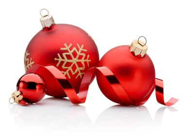 Three red Christmas decoration baubles and curling paper ribbon isolated on a white background