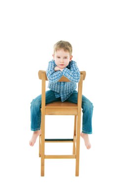 Neşeli çocuk sandalyede oturuyor.