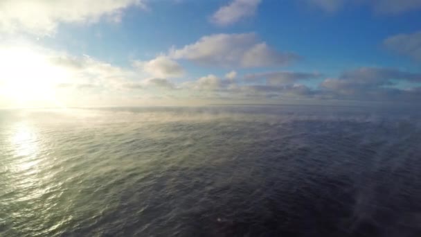 Beautiful scene: blue sunny sky with cumulus clouds, steam over the sea, the view from the boat — Stock Video