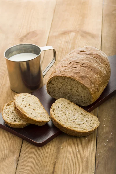 En limpa bröd på en styrelse och mjölk — Stockfoto