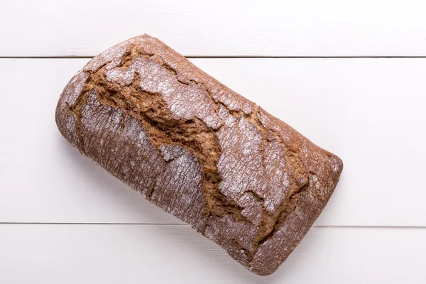 Freshly baked loaf of bread on a wooden table — Stock Photo, Image