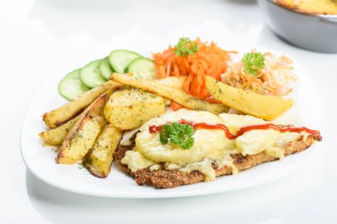 Hawaii pirzolası, fırında patates ve bir buket salata.