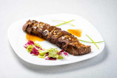 Biftek sosu beyaz tabağa döküldü.