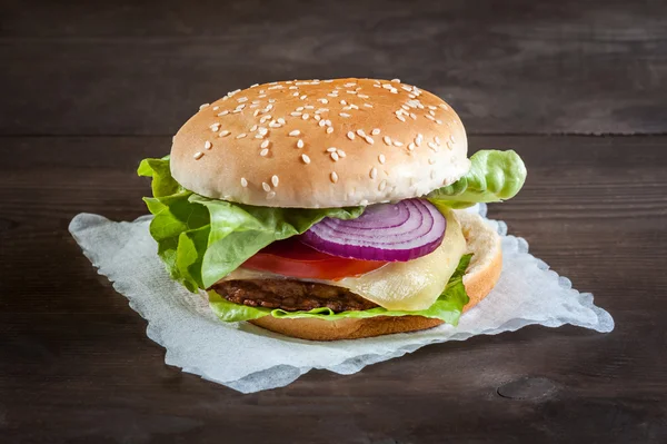 Hamburguesa en una servilleta en una mesa de madera —  Fotos de Stock