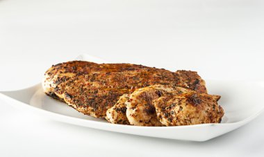 Beyaz tabakta ızgara tavuk göğsü.