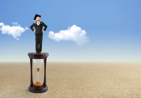 Businessman stands on hourglass — Stock Photo, Image