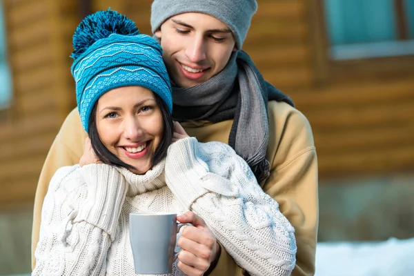 Hugging couple drinking tea outdoors — Stock Photo, Image