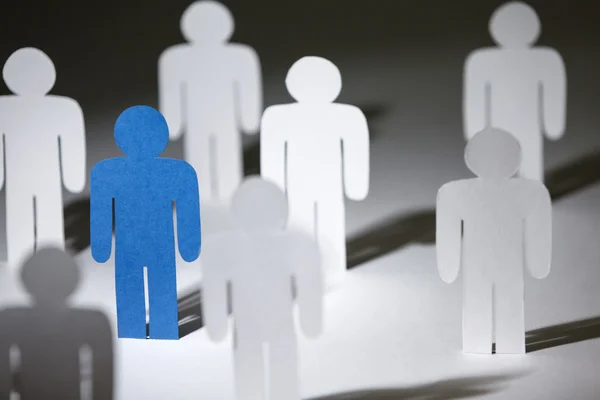 Group of similar paper people with a blue one — Stock Photo, Image