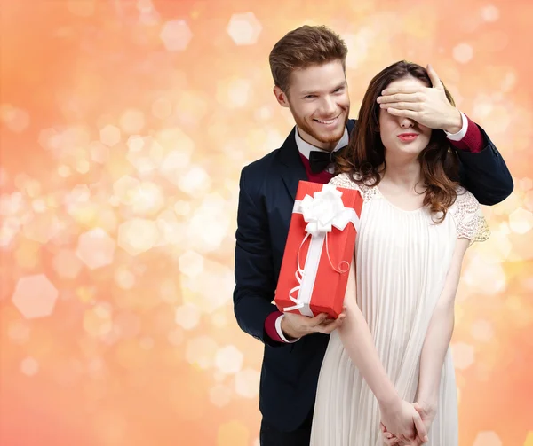 Het geven van een kerst aanwezig man sluit ogen van zijn vriendin — Stockfoto