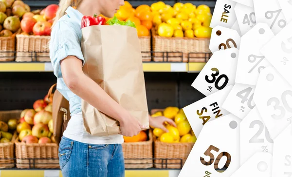 Girl hands bag with fresh vegetables choosing lemons at a good price — Stock Photo, Image
