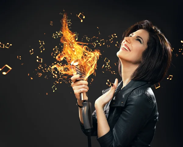 Female rock musician handing burning mic — Stock Photo, Image