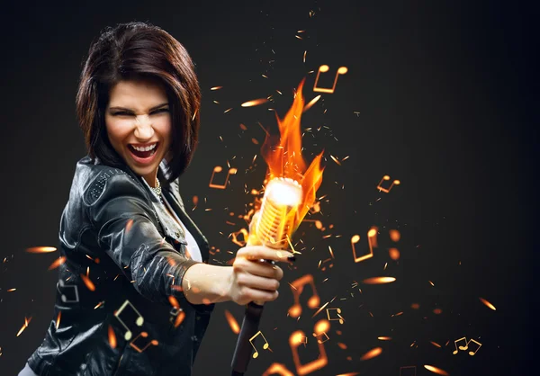 Ženské rockový zpěvák drží mikrofon v plamenech — Stock fotografie