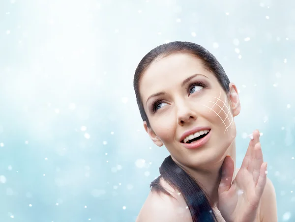 Woman applying face cream in winter — Stock Photo, Image