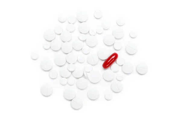 Red pill on heap of white tablets — Stock Photo, Image