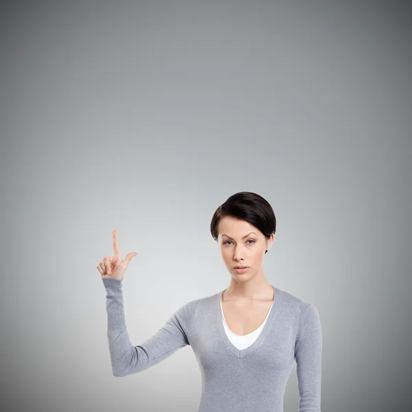 Junge Frau zeigt Zeigefinger, Aufmerksamkeitszeichen — Stockfoto