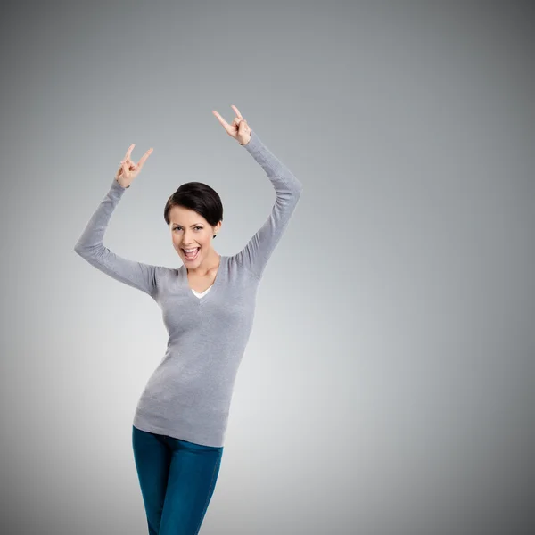 Glad pretty woman puts her hands up with two fingers pointed up — Stock Photo, Image