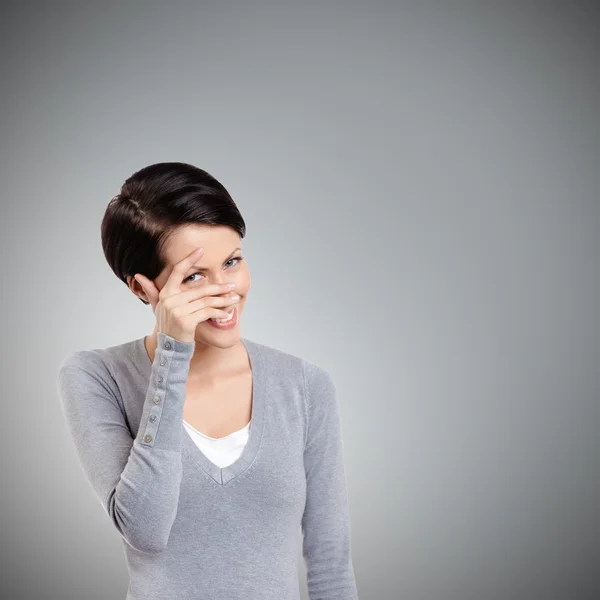 Beautiful young woman covers her eyes with hand — Stock Photo, Image