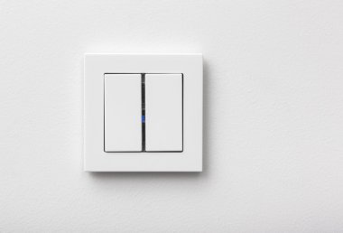 Modern light switch on the white wall clipart