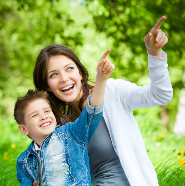 Moeder en zoon zit op gras — Stockfoto