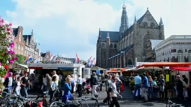 Grote kerk ("büyük kilise") üzerinde grote markt Haarlem, Hollanda Merkez market yakınındaki insanlar kare. — Stok video