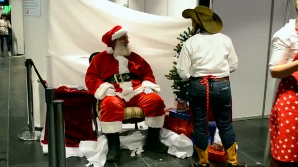 Santa Claus en el bazar de la caridad 2014 en Kiev, Ucrania. Stand de USA . — Vídeos de Stock