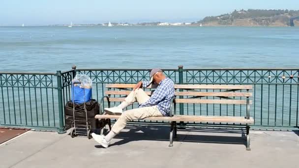 Hombre no identificado relajándose en un día soleado cerca de Bay Bridgein San Francisco, Estados Unidos . — Vídeo de stock