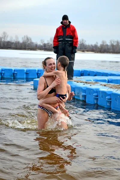 Mulher com criança em água fria, Epifania em Kiev, Ucrânia . Fotos De Bancos De Imagens