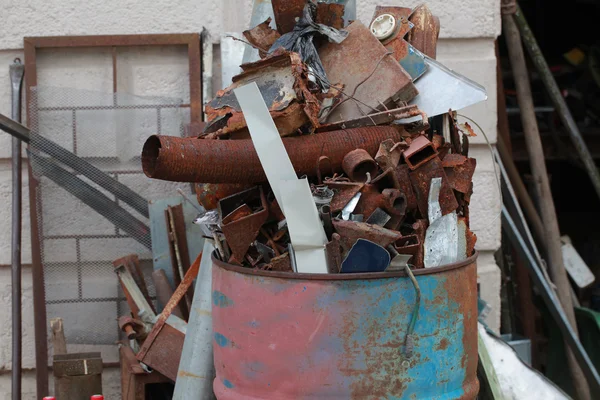 Roestige schroot in een vat met ijzer — Stockfoto