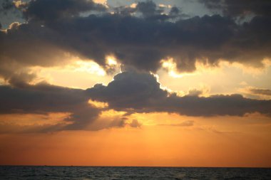 Akşamüstü gökyüzü bulutlu, gök gürültülü, günbatımı...