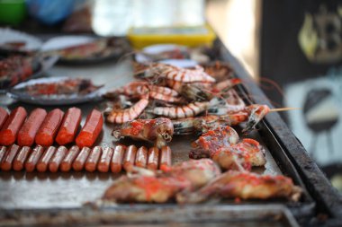 Taze balık ve deniz ürünleri bir sokak kafesinde kızartılıyor.