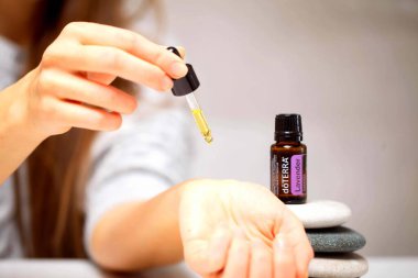 Belarus, Minsk, 2021. Elinde illüstrasyonal doterra yağı olan bir kadın.