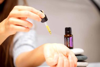 Belarus, Minsk, 2021. Elinde illüstrasyonal doterra yağı olan bir kadın.