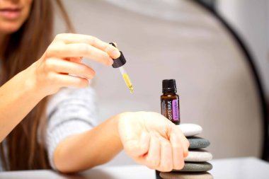Belarus, Minsk, 2021. Elinde illüstrasyonal doterra yağı olan bir kadın.