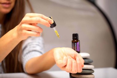 Belarus, Minsk, 2021. Elinde illüstrasyonal doterra yağı olan bir kadın.