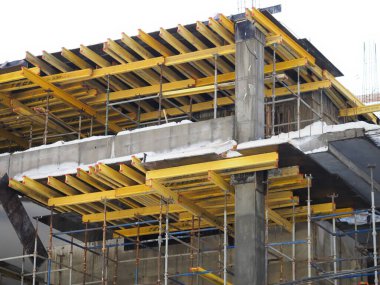 Kentsel gelişim. Gündüz vakti inşaat alanında. Üniformalı işçiler iskeleyi hazırlayın.