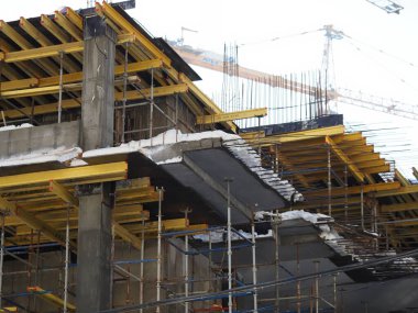 Kentsel gelişim. Gündüz vakti inşaat alanında. Üniformalı işçiler iskeleyi hazırlayın.